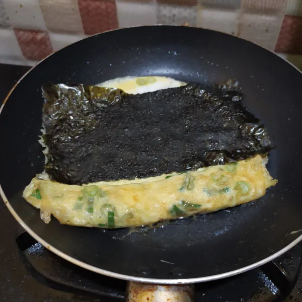 beri adonan telur lagi, tambahkan nori, gulung lagi.