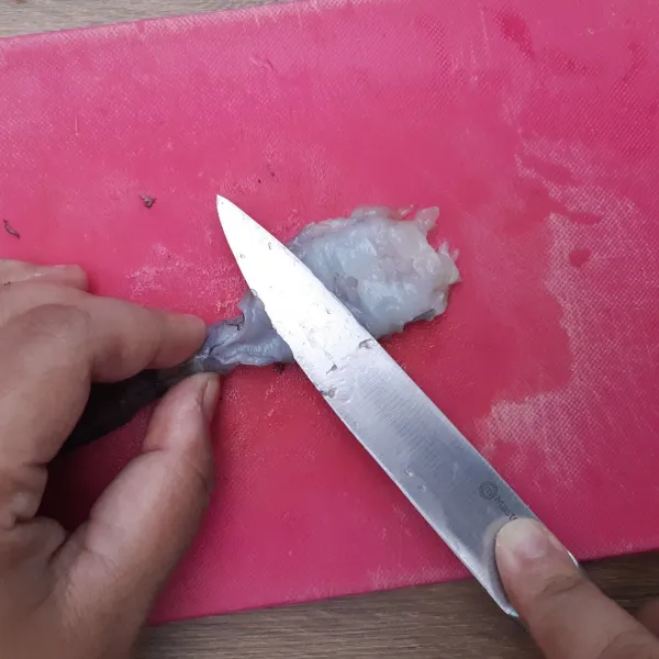 Balik kembali, tekan-tekan punggung udang dengan pisau. Langkah 1-4 bertujuan agar tempura tetap lurus saat digoreng.