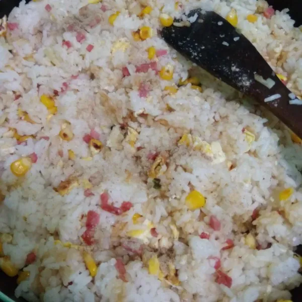 Masukkan nasi aduk rata, bumbui lada bubuk, kecap asin, garam dan kaldu jamur masak dengan api besar sambil diaduk rata.