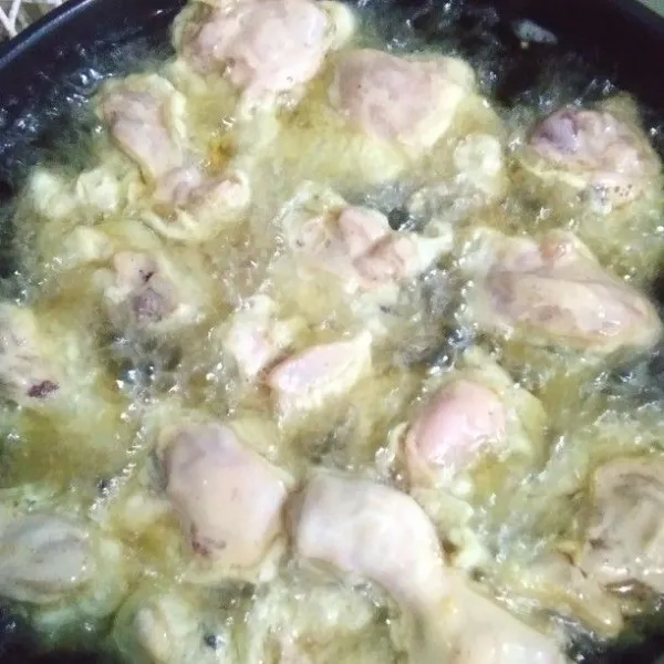 Panaskan minyak, goreng daging ayam berbalut tepung selama 20 menit. Gunakan api sedang, sesekali balik daging ayam supaya tidak gosong.