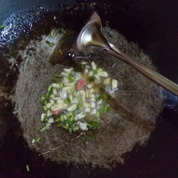 Tumis bawang putih dan daun bawang hingga harum.