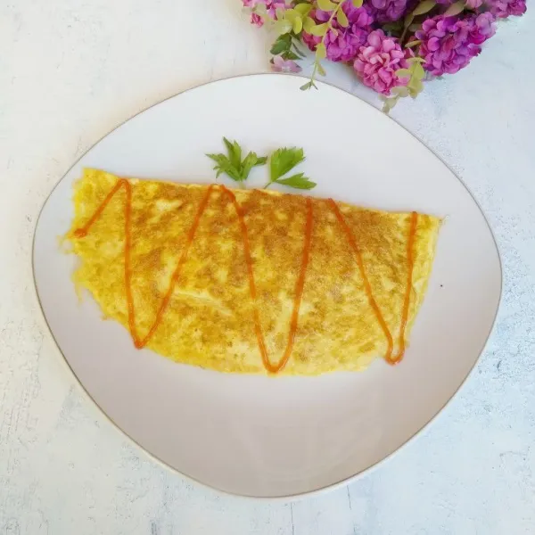 Lipat telur dadar hingga menyelimuti nasi goreng.