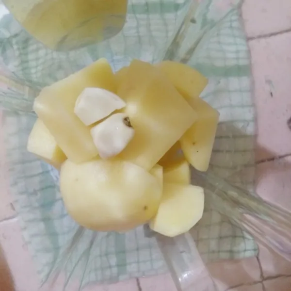 Masukkan potongan kentang dan bawang putih kedalam gelas blender kemudian blender hingga halus.