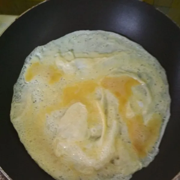 Kocok telur, garam, dan penyedap jamur, lalu dadar telur tipis tipis hingga matang.