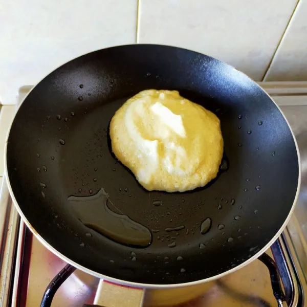 Tuang adonan pancake ke atas pan yang telah dioleskan mentega dan panas.