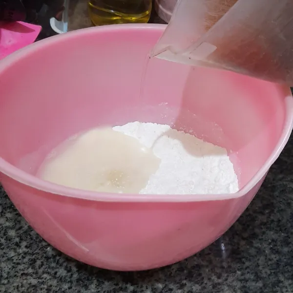 Untuk membuat kulit gyoza, campur dan aduk rata tepung terigu bersama garam. Tuang air panas, lalu uleni selama 10 menit hingga kalis.