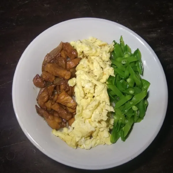 Siapkan mangkuk, masukkan nasi, lalu di atasnya susun ayam, telur orak-arik dan sayur. Siap disajikan.