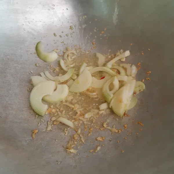 Tumis bawang putih dan bawang bombay hingga layu.