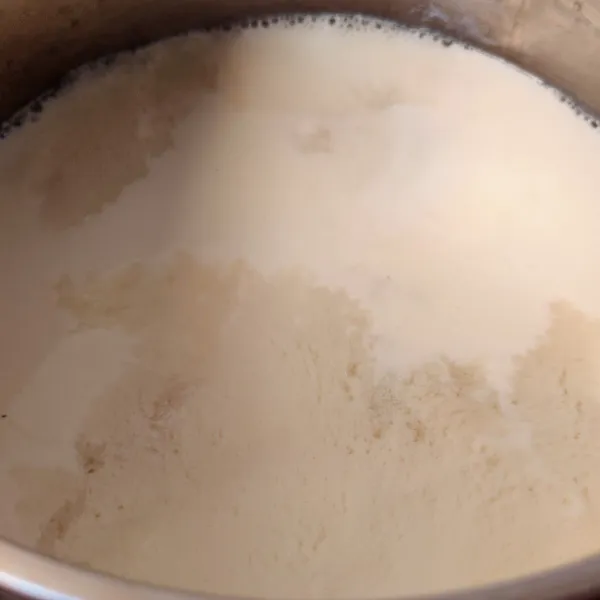 Membuat puding: Campir susu UHT dengan gula pasir dan vanili, aduk rata dan masak sambil diaduk sampai mendidih. Setelah mendidih, matikan api