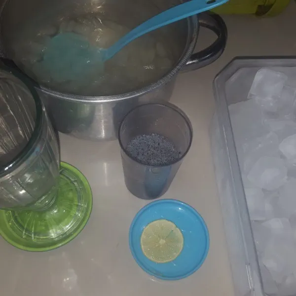 Tuangkan es batu dalam gelas, tambahkan lidah buaya, sirup, dan biji selasih yang sudah direndam air