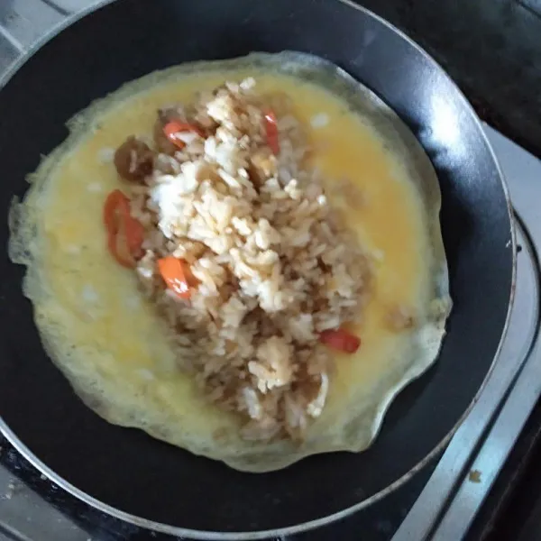 Setelah itu masukkan nasi di atas telur kemudian gulung telur, hinga nasi tertutup kemudian angkat sajikan.