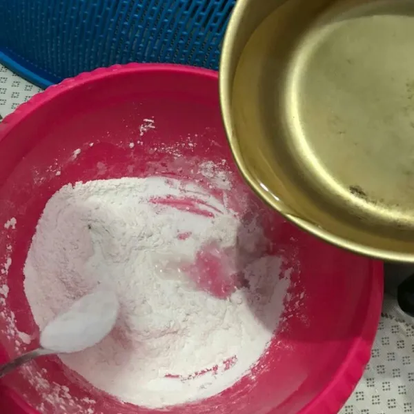 Tambahkan air panas sedikit demi sedikit hingga adonan kalis.