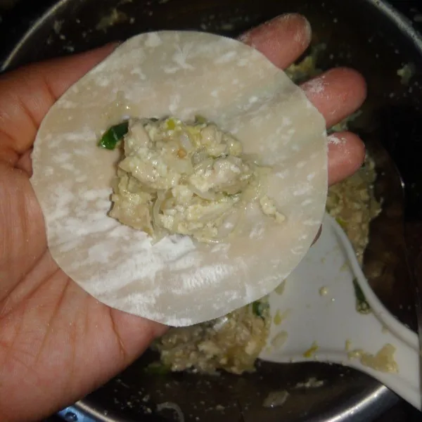 Taruh kulit di telapak tangan, tuang 1 sendok adonan atau sesuaikan dengan kulit.