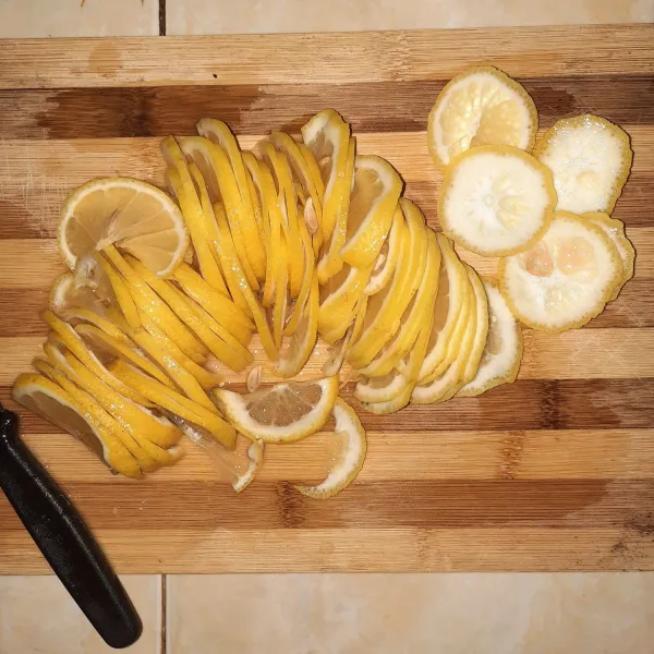 Buang bagian ujung lemon, lalu diiris tipis.