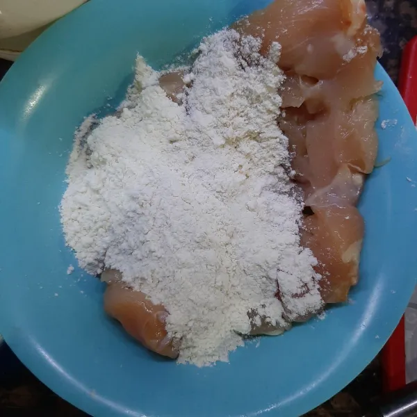 Tambahkan tepung ke atas ayam, aduk rata hingga ayam terbalur tepung. Cubit-cubit agar tepung lebih menempel.