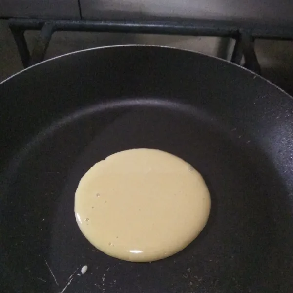 Panaskan wajan anti lengket, lalu tuangkan 1 sendok sayur.