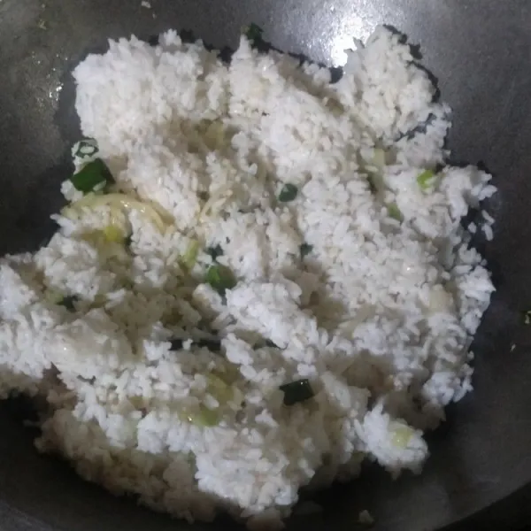 Masukkan nasi, garam, lada, dan gula. Aduk hingga rata.