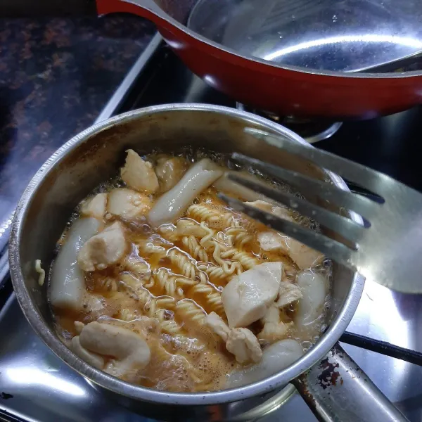 Masukan tteokbokki, masak hingga kuah agak mengental, lalu masukan mie dan masak hingga matang.