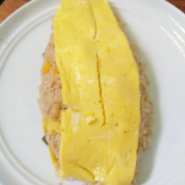 Tata di atas nasi goreng, beri saus sambal dan sajikan.