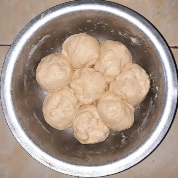 Kempiskan adonan, lalu bagi adonan menjadi 8 bulatan. Biarkan kurang lebih 15 menit, dan adonan kembali mengembang