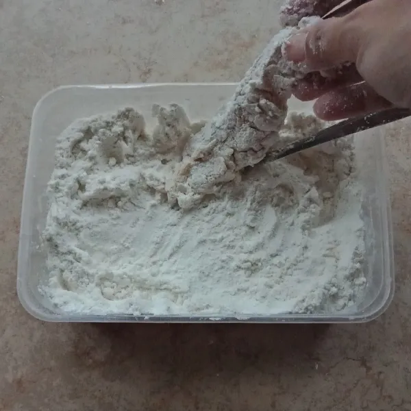Ambil ayam yang sudah dimarinasi, baluri tepung, celup lagi ke bahan marinasi, baluri lagi dengan tepung.