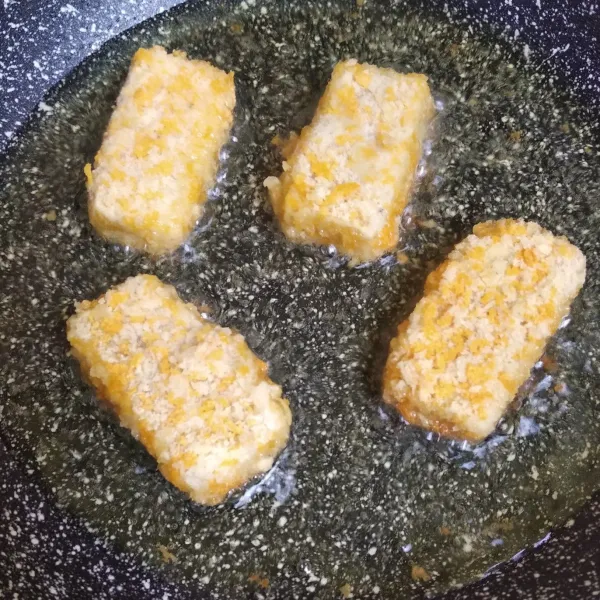 Goreng nugget dengan minyak panas api sedang sampai kekuningan.