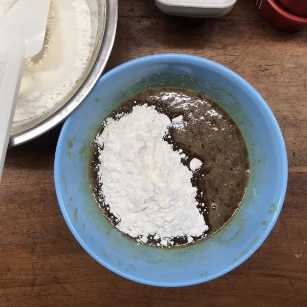 Ketika step 5 sudah tercampur rata, masukkan 1/2 adonan kering (campuran tepung protein sedang, baking soda, dan garam), kemudian aduk sampai rata.