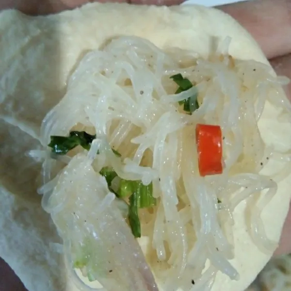 Terlebih dahulu taburi tangan dengan terigu supaya adonan pastel tidak lengkat, ambil adonan pastel secukupnya, bulatkan dan ratakan isi bagian tengah adonan dengan bihun.