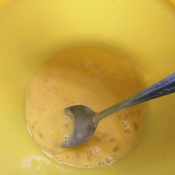 Kocok lepas telur di dalam wadah.