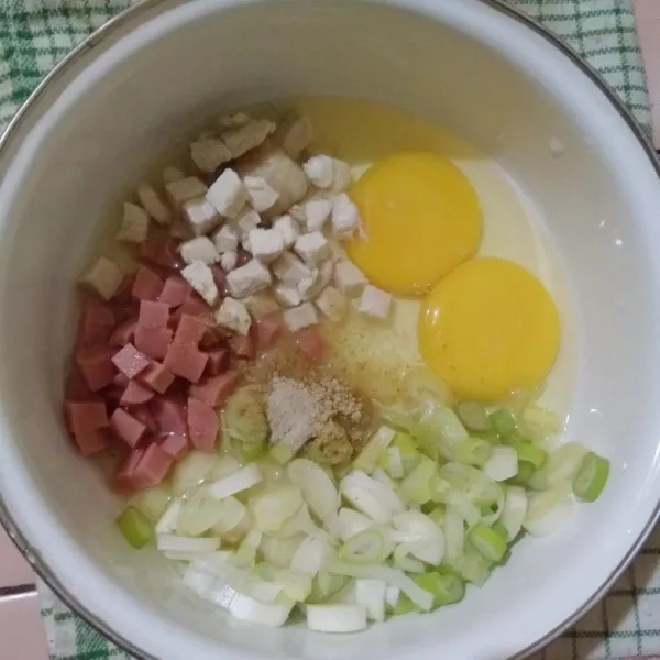 Masukkan telur, potongan sosis, potongan ayam rebus, irisan daun bawang, garam dan merica bubuk kedalam wadah.