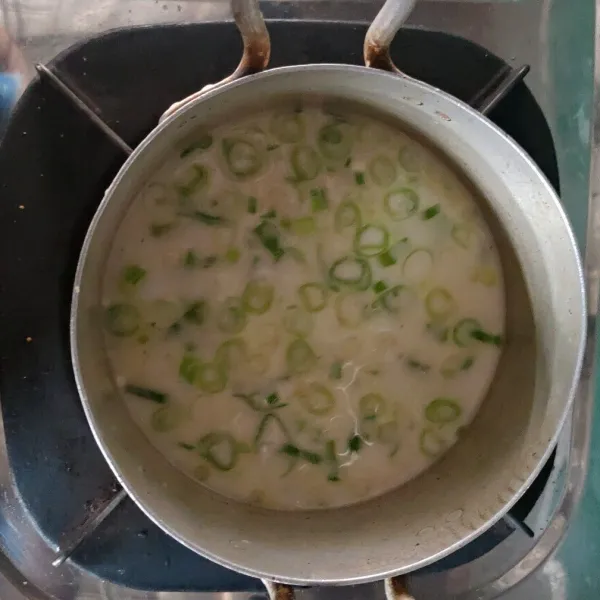 Masukan bawang putih yg telah di haluskan, daun bawang, garam, gula, kaldu ayam, lada bubuk, dan tepung tapioka yang ada di piring kecil lalu aduk dengan air hingga merata, setelah merata dan tidak ada yg menggumpal panaskan dengan api sedang sambil terus di aduk dengan spatula kayu.