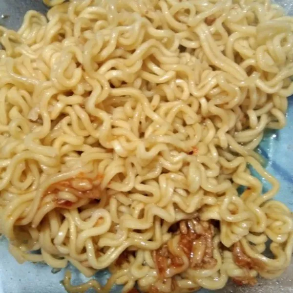 Masak mie goreng instan sesuai dengan petunjuk di kemasan, sisihkan.