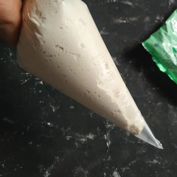 Masukkan ke plastik segitiga, gunting ujungnya.