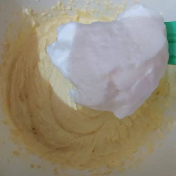 Masukkan adonan putih telur secara bertahap kedalam adonan kuning telur. Aduk pakai spatula.