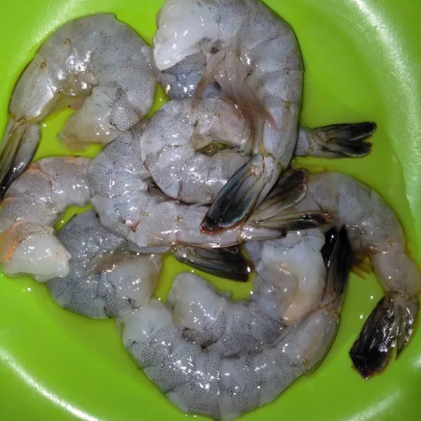 Kupas kulit dan buang kepala udang kecuali ekor kemudiam cuci bersih.