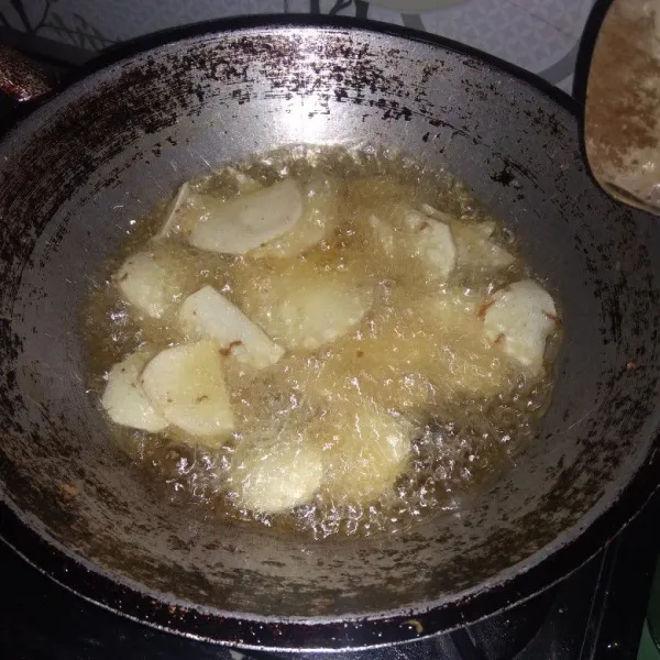 Panaskan minyak, goreng talas, siram dengan larutan garam dan kaldu bubuk, goreng sampai kering kuning keemasan.