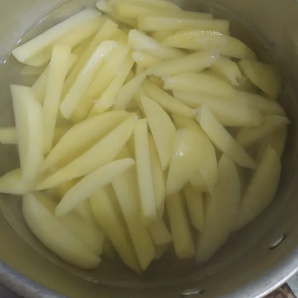 Potong kentang memanjang, lalu rebus setengah matang angkat dan tiriskan.