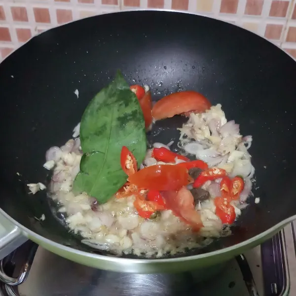 Tumis bawang merah dan bawang putih sampai harum, masukkan cabe, tomat, daun salam dan terasi, tumis sampai layu.