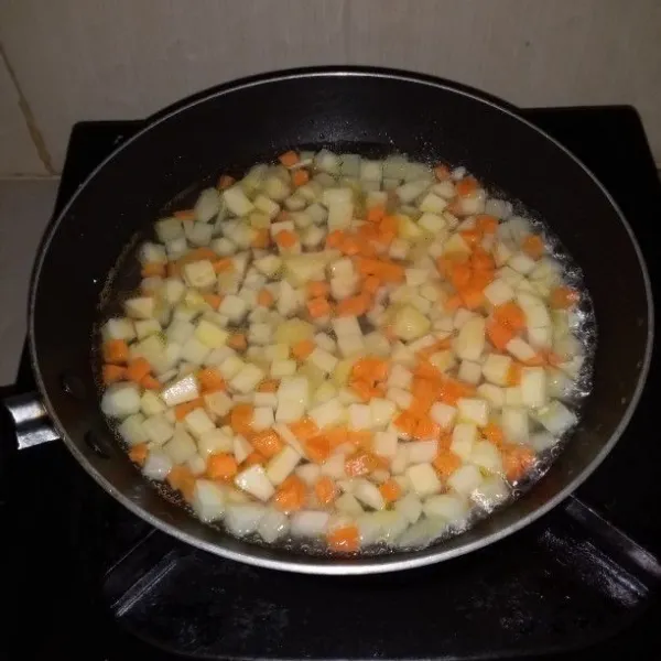 Kupas wortel dan kentang. Cuci dan potong dadu kecil. Kemudian rebus hingga empuk. Angkat dan tiriskan.