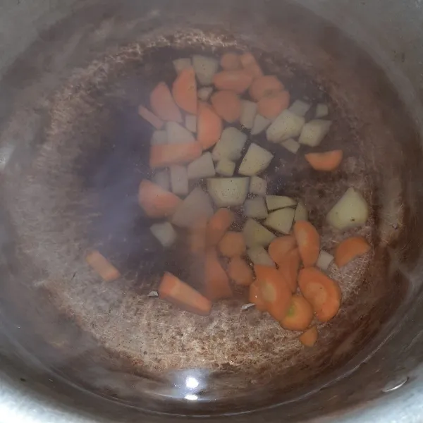 Masukan kentang dan wortel ke dalam air, kemudian masak dengan air sampai mendidih.