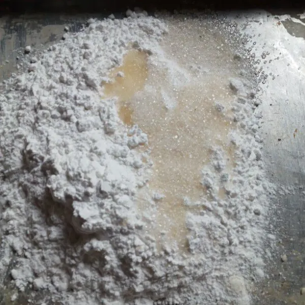 Siapkan wadah masukkan tepung ketan gula pasir dan air hangat aduk sampai rata.