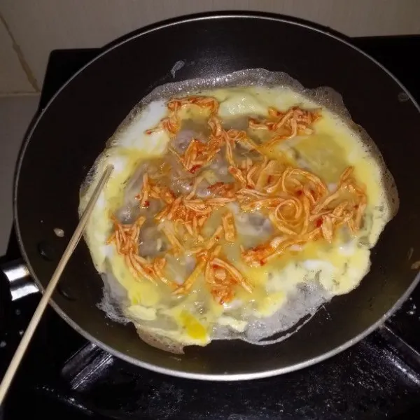 Panaskan teflon, oles dengan sedikit minyak. Tuang adonan 1 sendok sayur, putar teflon. Tuang 2 sdm telur kocok, ratakan. Setelah matang, gulung dengan tusuk sate. Langsung celupkan ke dalam tepung roti sangrai.