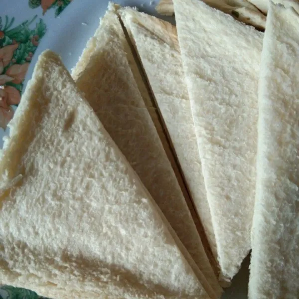 Potong roti tawar menjadi 2 bagian bentuk segitiga, sisihkan.