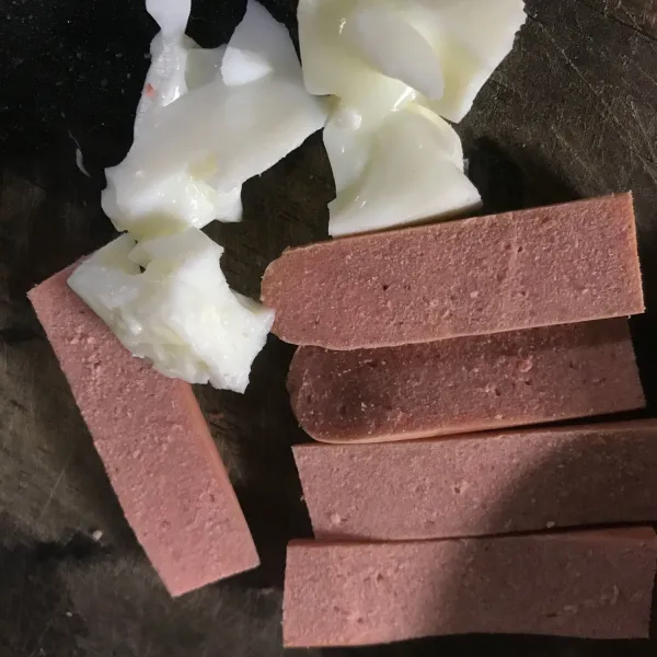 Rebus putih telur lalu potong potong. Siapkan sosis belah dua lalu potong sepanjang ruas jari.