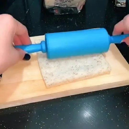 Pipihkan roti tawar menggunakan rolling pin.