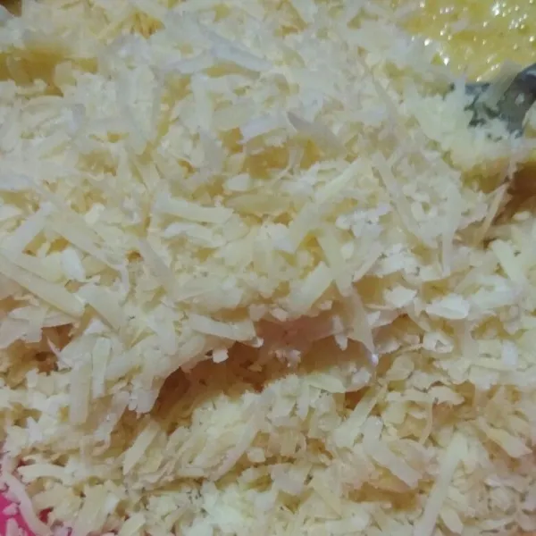 Tambahkan keju parut, lalu aduk rata.