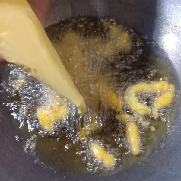 Masukkan ke pipping bag lalu spuitkan ke minyak goreng yang telah dipanaskan, goreng hingga kuning kecokelatan. Angkat dan tiriskan.