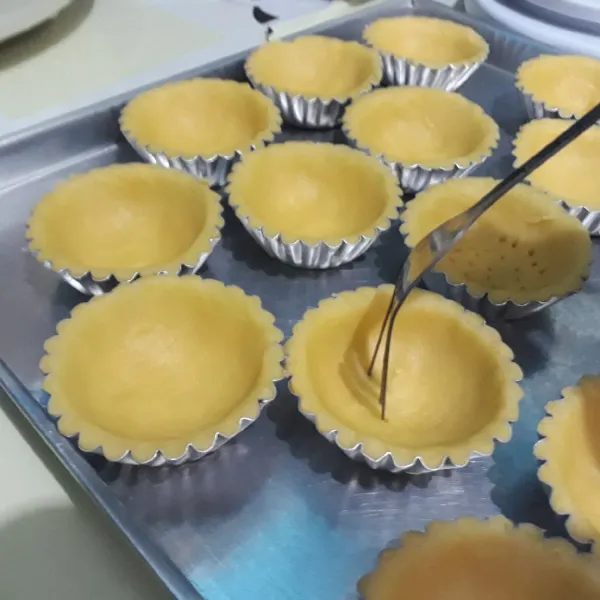Cetak adonan dengan cetakan pie, lalu tusuk-tusuk bagian dasarnya dengan garpu.
