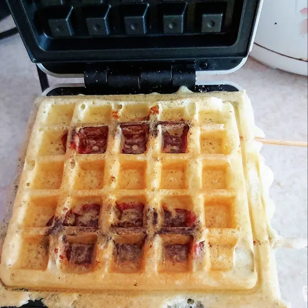 Panggang waffle hingga matang dan kering kedua sisinya berwarna kuning kecoklatan, lalu angkat lakukan hingga selesai.