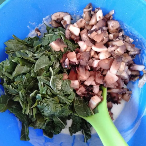 Masukkan irisan daun singkong dan potongan jamur kancing ke dalam adonan tepung basah. Aduk sampai tercampur semua.